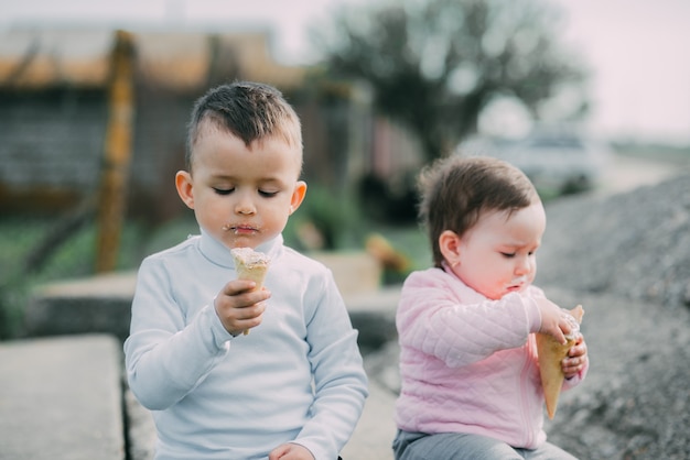 Little kids eating ice cream outdoors in the village