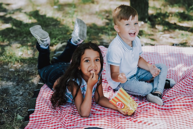little kids have pop corn in park family picnic