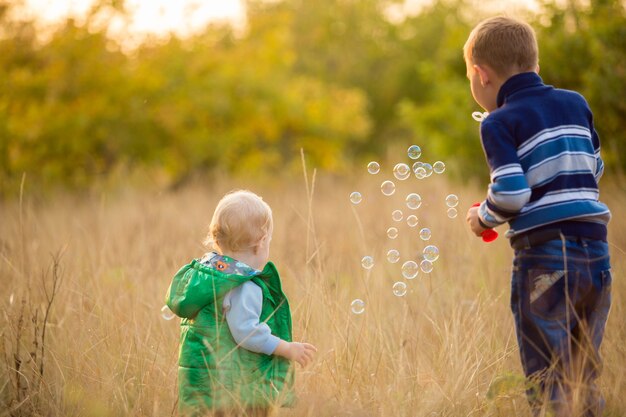 I bambini piccoli lasciano bolle di sapone in natura