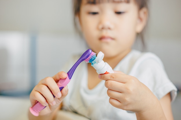 Little kids using toothbrush for brushing her teeth