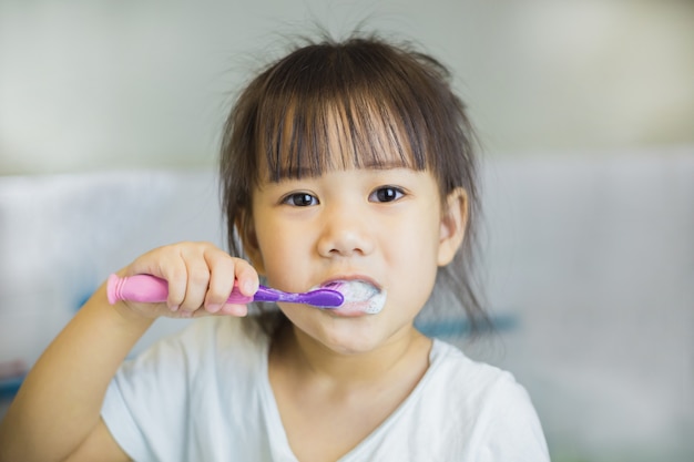 Little kids using toothbrush for brushing her teeth