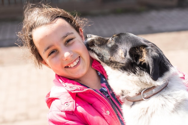 Little latin girl with her big dog in the countryside