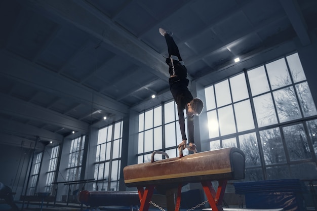 Little male gymnast training in gym flexible and active