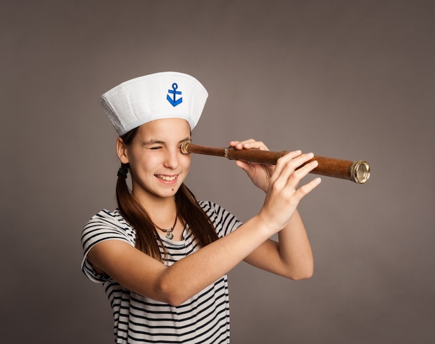 Little marine looking through spyglass on gray