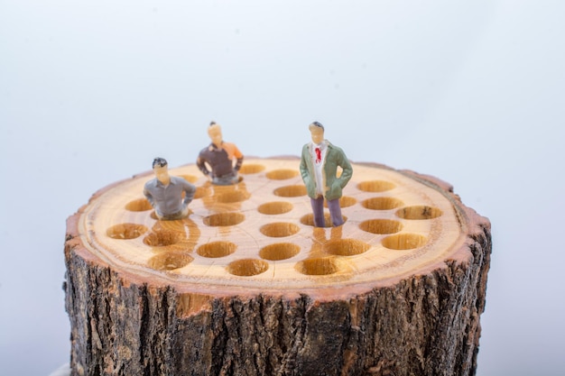 Little men figurines places on wooden log