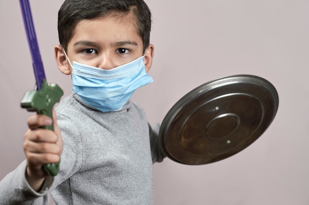 Little moddle-eastern kid in face mask having fun during covid-19 quarantine