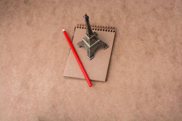 Photo little model eiffel tower notebook and pencil