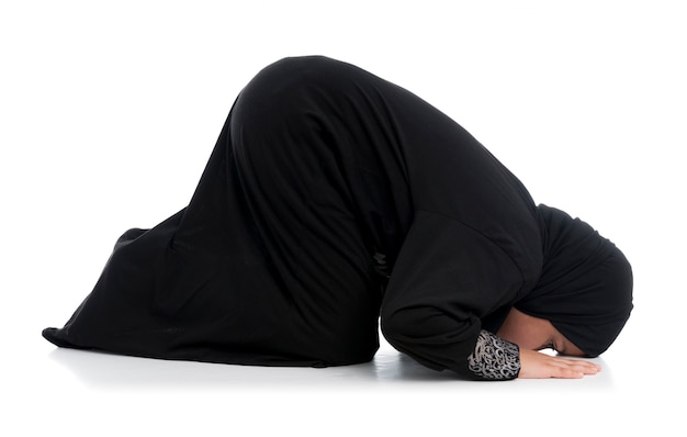 Little Muslim girl praying in a traditional costume