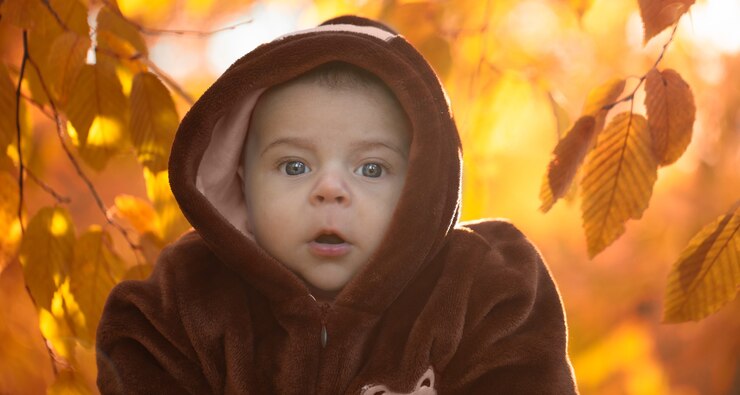 Little newborn boy, close up on a background of autumn leaves