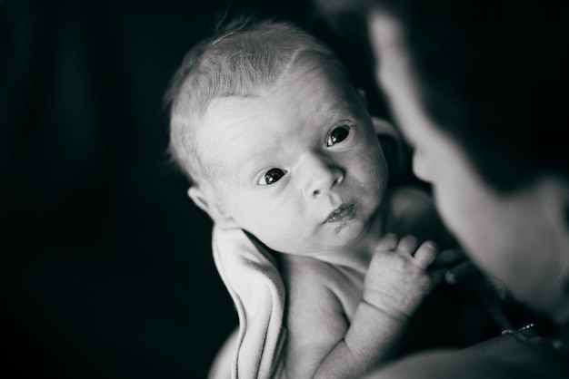 Little newborn boy in his father's arms