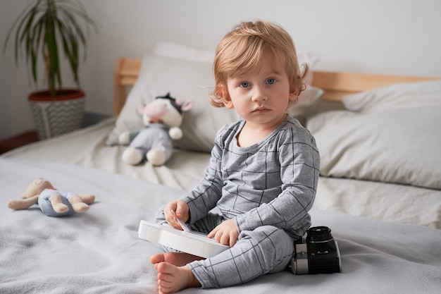 Little one year old boy playing on the bed with his favorite toys Lifestyle photo