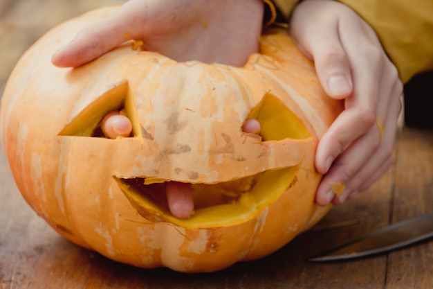 Little orange pumpkin, jack-o-lantern on wooden table