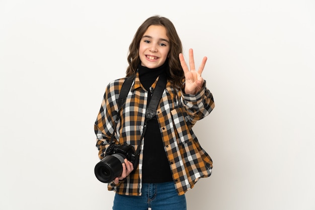 Little photographer girl isolated on wall happy and counting three with fingers