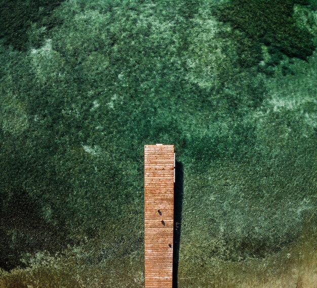 Photo little pier leading into clear green water in a lake near munich