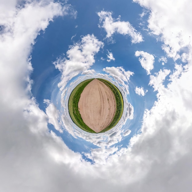 Преобразование маленькой планеты сферической панорамы 360 градусов Сферический абстрактный вид с воздуха в поле в хороший день с потрясающими красивыми облаками Кривизна пространства