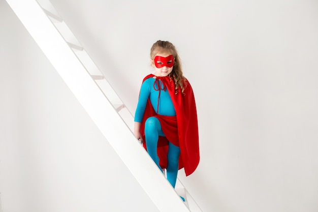 Little power super hero child girl in a red raincoat Superhero concept