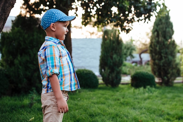 Little preschool boy playing soccer on the backyard lawn