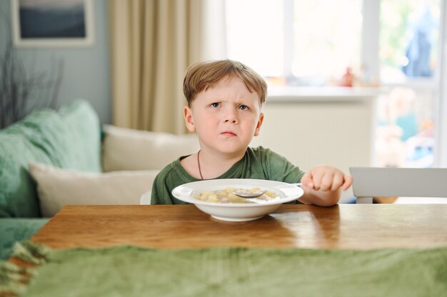 小さな就学前の子供がスープを食べる