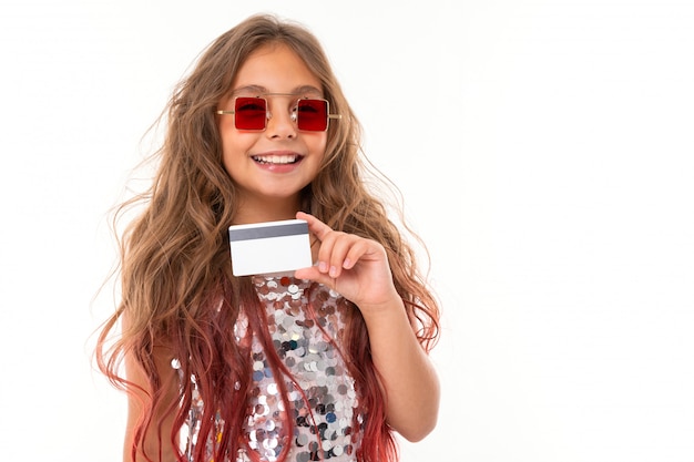 Little pretty caucasian girl with plastic card, picture isolated on white wall