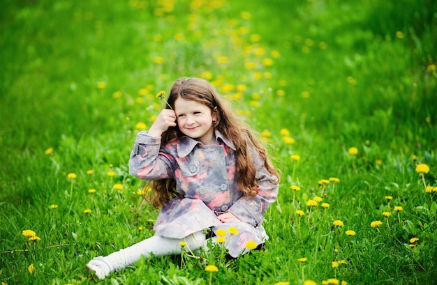 Маленькая красивая девочка в зеленом саду