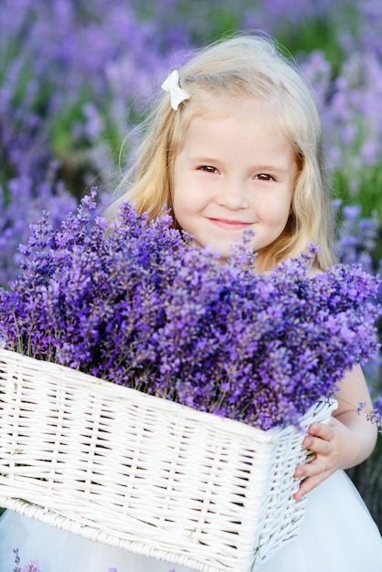 Little pretty girl holding lavender in the basket