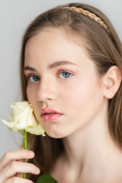 Little pretty girl in pink holds the bouquet of roses. Close up the flowers and face, little ballerina with a bouquet