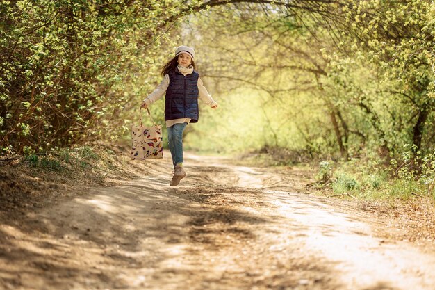 Little pretty girl on walk in sunny spring park Fairy forest