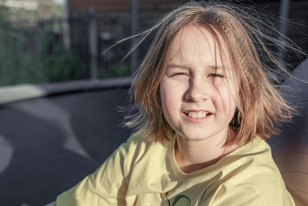 Photo little pretty smiling girl sitting on the trampoline