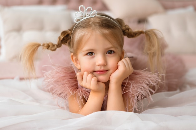 Photo little princess in an evening dress is lying in a beautiful bed