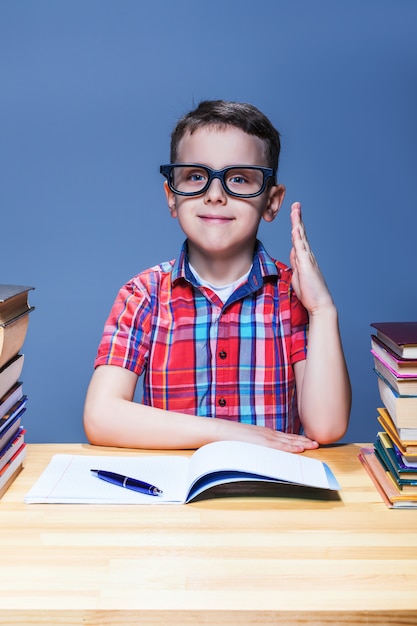 Photo little pupil pulls a hand up in the classroom