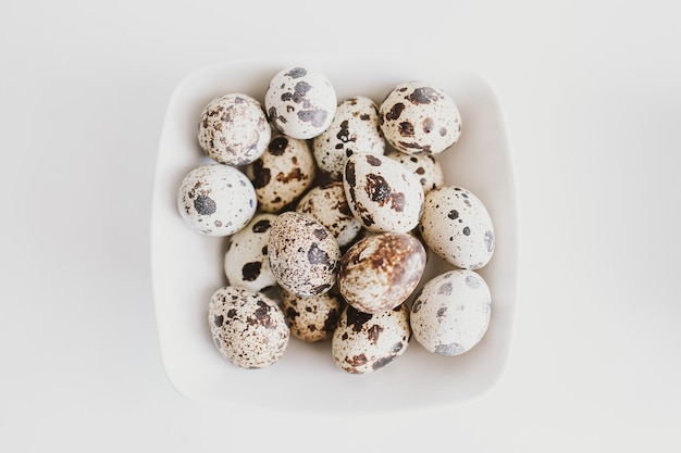 Photo little quail eggs in a white cloth on a light background