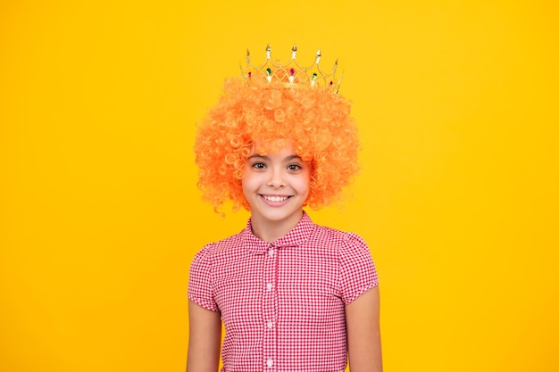 Little queen in wig wearing golden crown Teenage girl princess holding crown tiara Prom party childhood concept