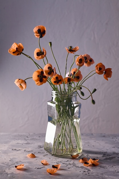 A Little Red Poppies Bouquet Arranged In Classical Style Stillife of popies in a glasses vase on vintage shair