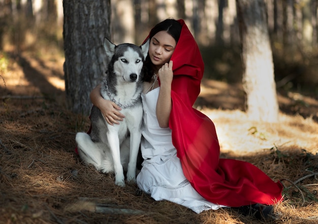 Photo little red riding hood with adorable husky