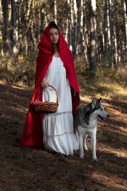 Photo little red riding hood with adorable husky