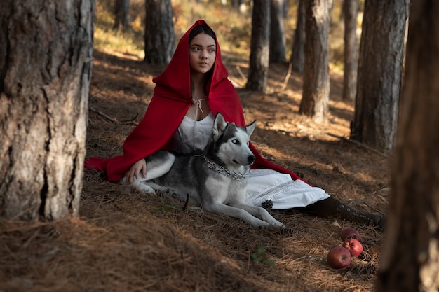 Photo little red riding hood with adorable husky