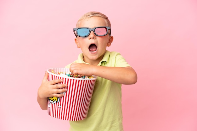 Little Russian boy eating popcorns in a big bowl over isolated background