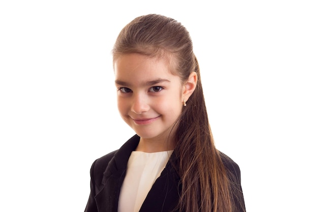 Little sad girl with long ponytail in white Tshirt black jacket on white background in studio