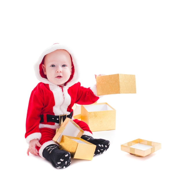 Маленький мальчик Санта с золотыми подарочными коробками, изолированные на белом фоне