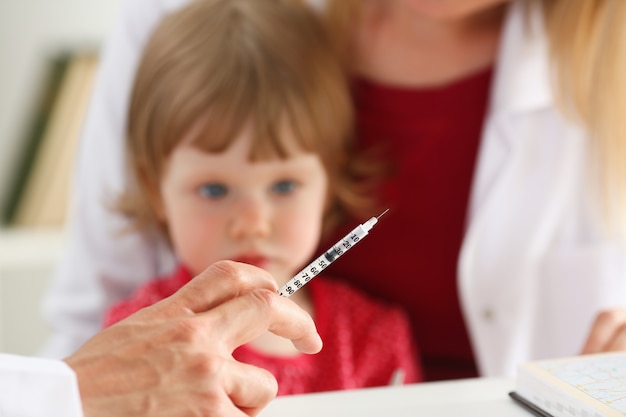 Little scared child at doctor reception make insulin shot