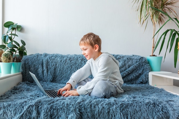 Little school boy having video call, online class on laptop  E-learning, distance studying, distance communication concept