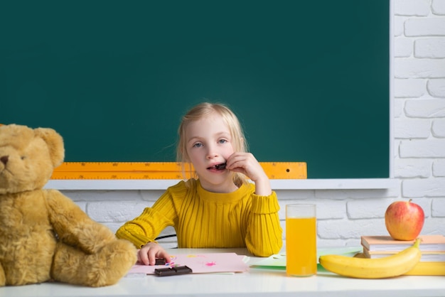 Little school girl student eating chocolate in class study english language at school Genius child knowledge day Kids education and knowledge