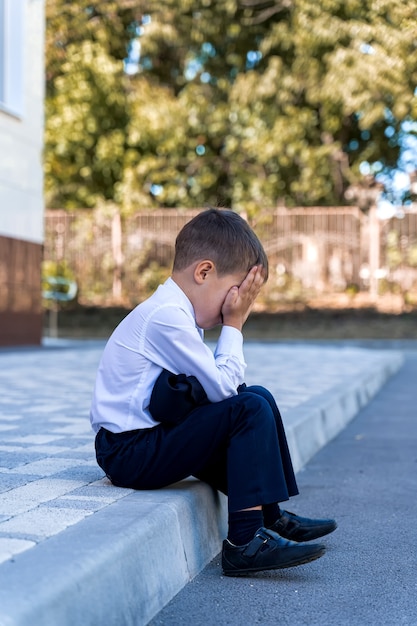 a little schoolboy is crying at school
