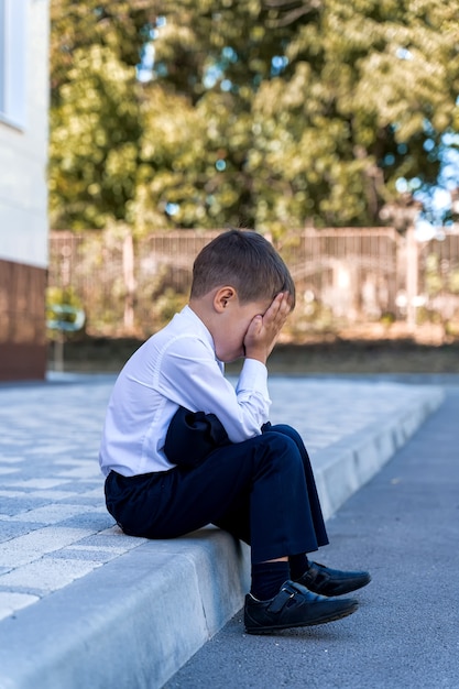 Un piccolo scolaro piange a scuola