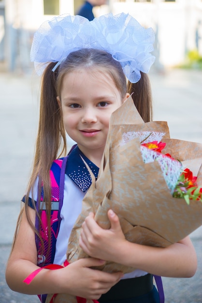 little schoolgirl girl going to school with flowers