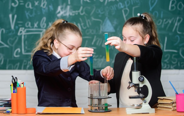 Little scientist teamwork with microscope chemistry research in\
laboratory biology lab successful teamwork science experiments in\
laboratory perfect team little girls in school lab teamwork