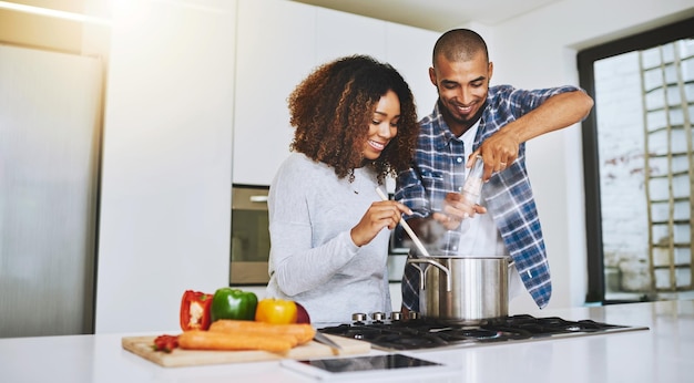 Little seasoning never hurt anybody Shot of a young couple cooking together at home