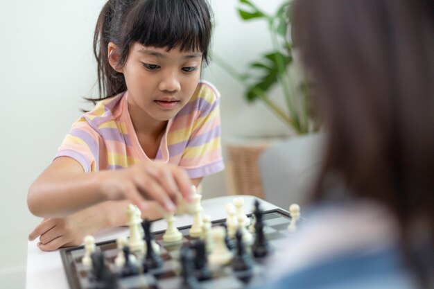 집에서 체스를 두는 작은 형제 소녀.