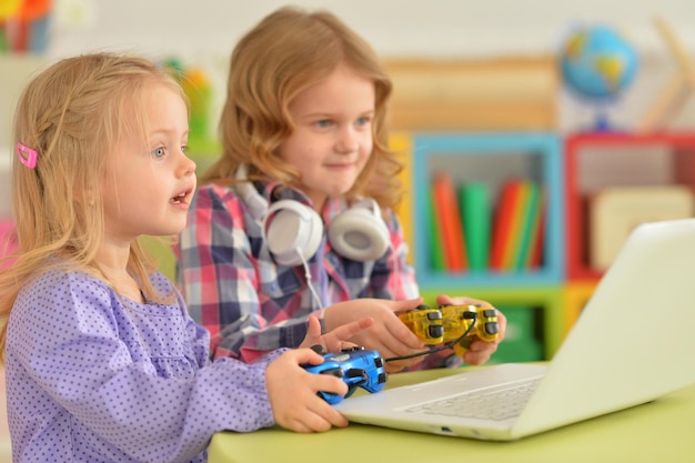 Little sisters playing computer game