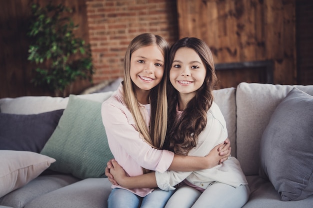 Premium Photo | Little sisters posing on the couch together